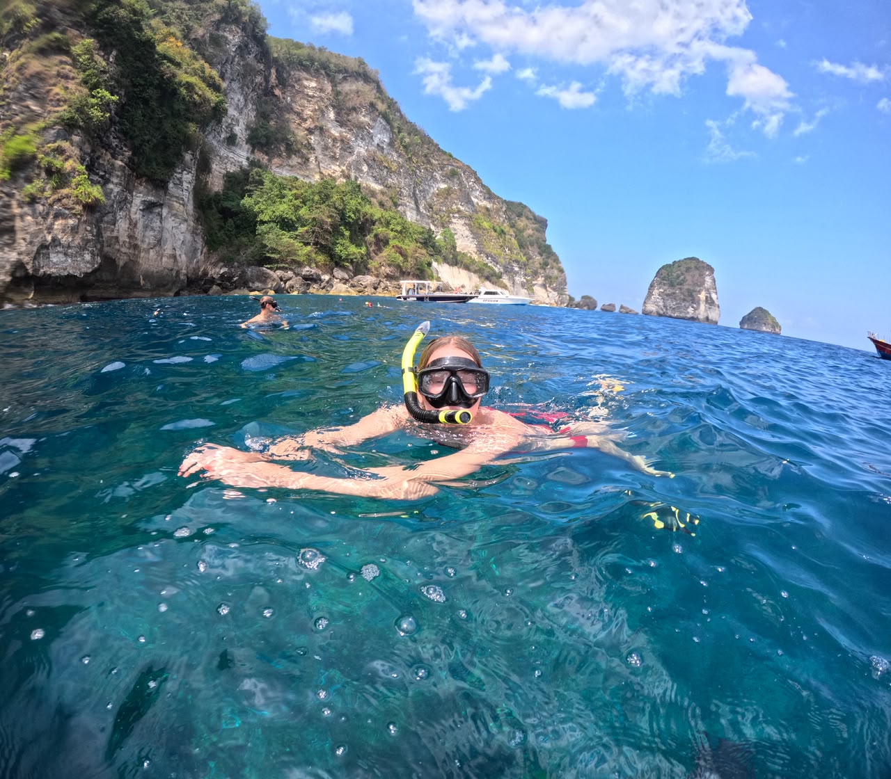 Snorkeler swimming below the cliffs of Nusa Penida